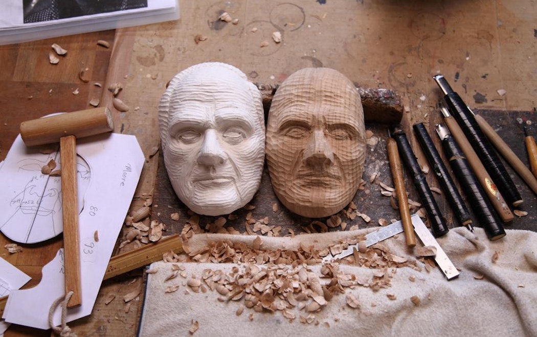 Hand crafted masks of faces carved from two different woods with different colours